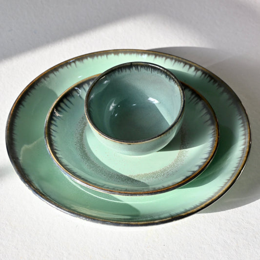 Set of green ceramic plates with brown rim on a white background from Saabi House