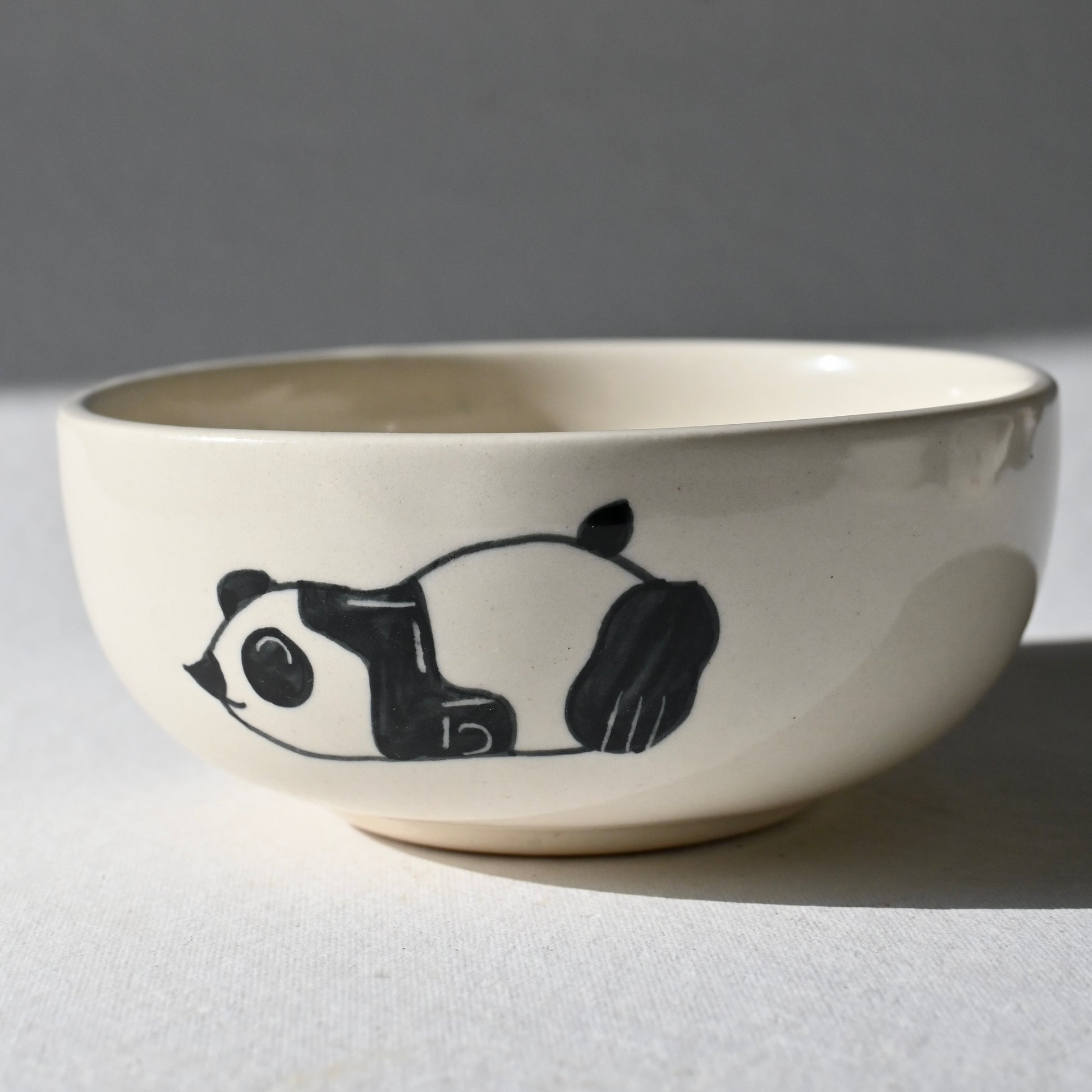 Ceramic bowl with a panda design on a gray background