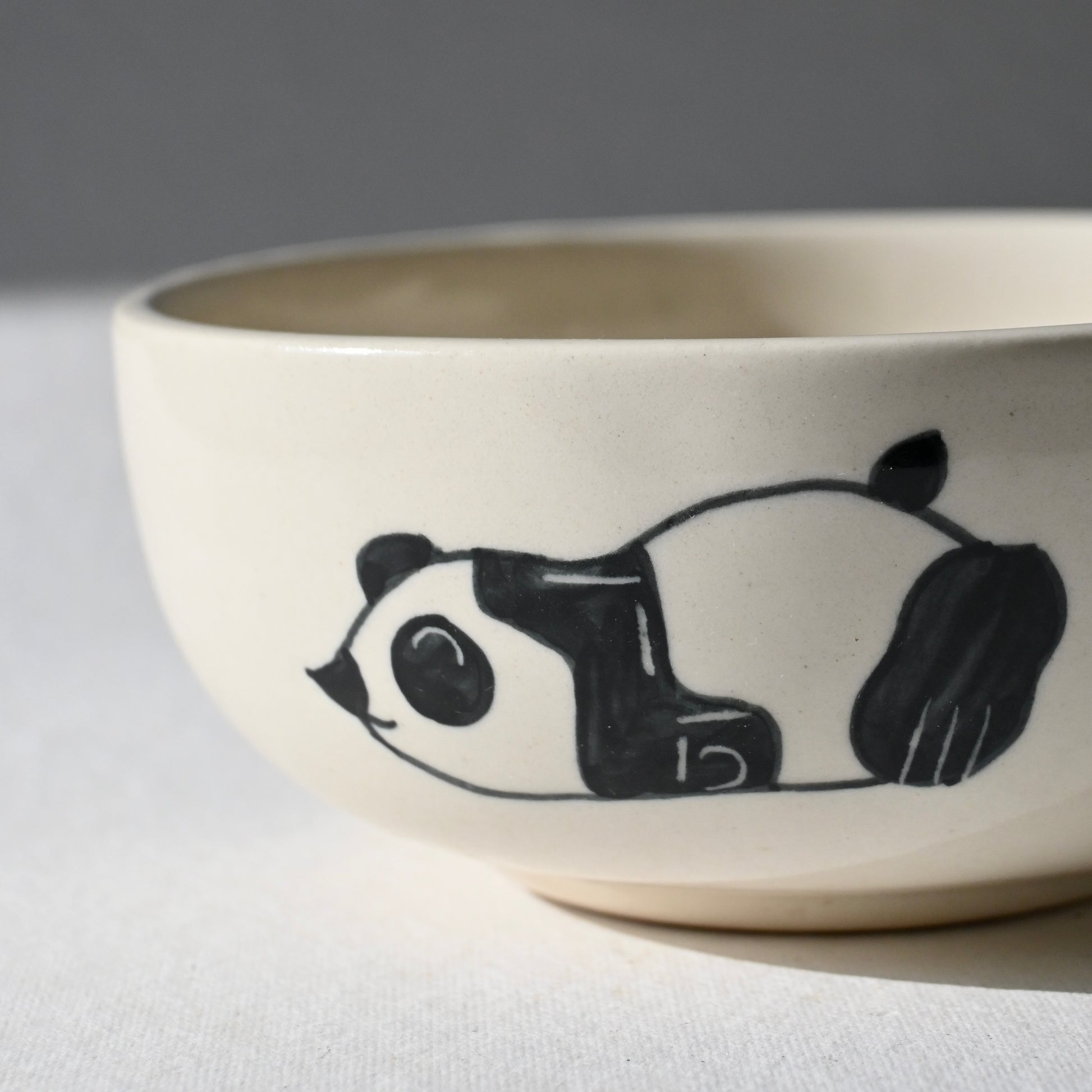 Ceramic bowl with a panda design on a white surface from Saabi House