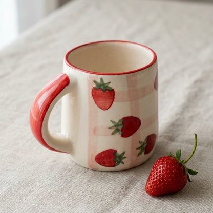Ceramic mug with strawberry design on a light fabric background