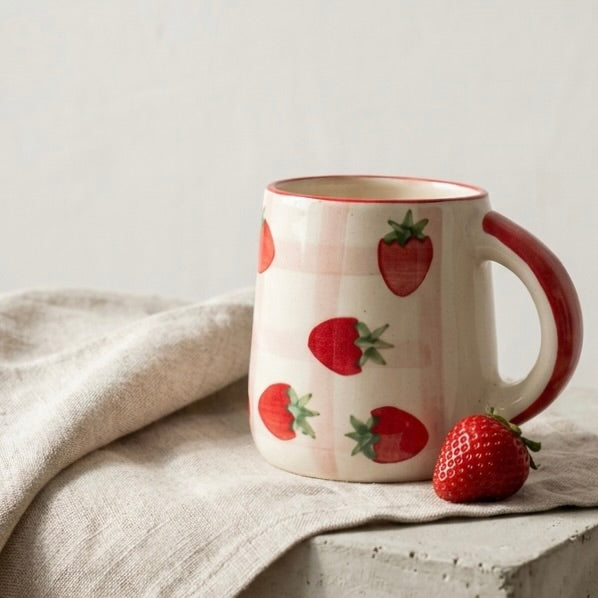 Ceramic mug with strawberry pattern on a neutral background