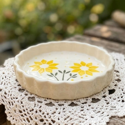 Ceramic dish with yellow floral design on a lace doily